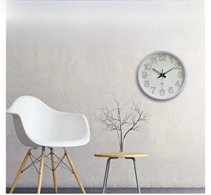 Modern white wall clock with luminous green numbers and silent quartz movement in home setting