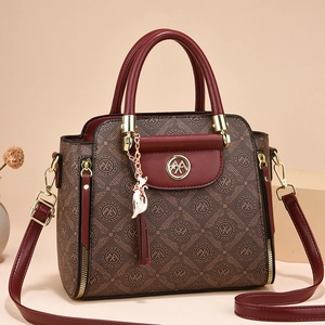 Elegant brown monogram handbag with red accents, cat pendant, and gold hardware