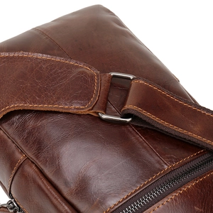 Close-up of premium brown leather stitching and durable metal D-ring for chest bag