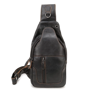 Detail of black genuine leather chest bag featuring contrast orange stitching and metal hardware