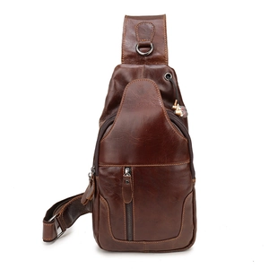 Detail of vintage brown leather chest bag showing headphone port and metal zipper