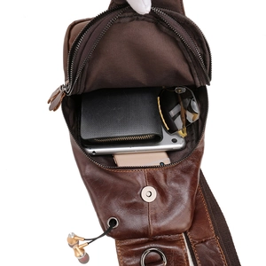 Interior detail of a brown leather chest bag showing capacity for phone, wallet and sunglasses
