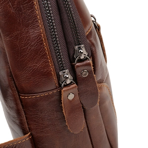 Detailed macro shot of vintage dark brown oily leather and dual zippers on chest bag