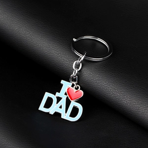 Détail macro du porte-clés en métal I Love Dad avec lettres bleu clair sur fond de cuir