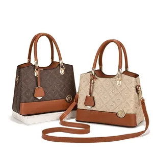 Detail of elegant monogram tote bags in brown and beige with golden hardware