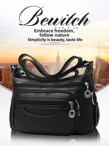 Close-up of black leather shoulder bag featuring multiple functional zipper pockets