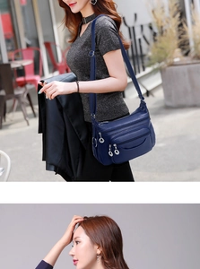 Street style shot of a dark blue multi-layer soft leather crossbody bag for women