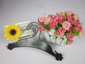 Close-up of black dog paw plastic hanger with non-slip hooks on a white wooden seat