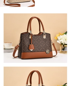 Detail of elegant monogram shoulder bag with leather handles and gold-tone hardware