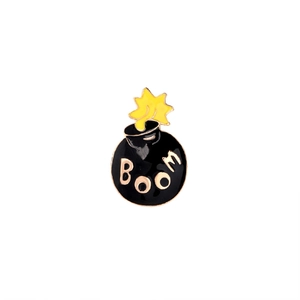 Cartoon style black enamel bomb brooch with golden BOOM lettering and yellow fuse detail
