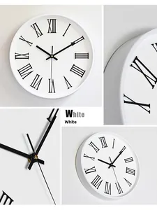 Détail d'une horloge murale blanche avec chiffres romains noirs et axe d'aiguille doré