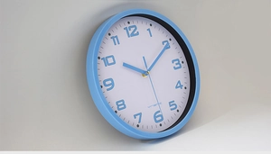 Detail view of the sky blue frame and 45-degree profile of the modern round wall clock