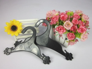 Detail of dog paw shaped plastic pet hangers in black and translucent grey with logo