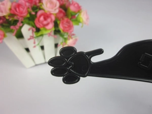 Detailed close-up of a black plastic pet hanger featuring a unique paw print hook design