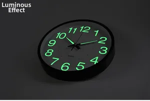 Detailed view of luminous green numerals and quartz movement on a black modern wall clock