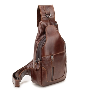 Detail view of brown genuine leather chest bag with zipper pockets and metal hardware