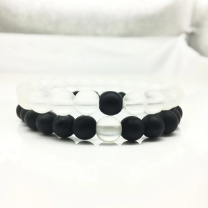 Primer plano de pulseras de cuentas de 8mm en piedra negra mate y turquesa blanca para pareja