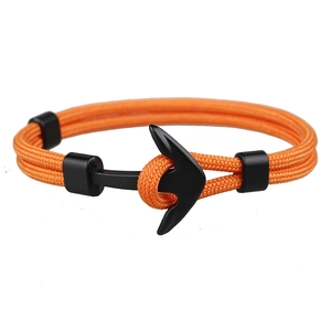 Detail of orange paracord bracelet featuring a black matte anchor clasp and sliding loops