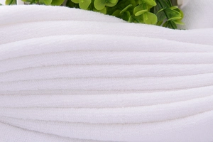Close-up of premium white cotton bath towel texture showing soft fibers and dense pile