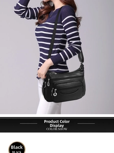 Close-up of black lychee grain shoulder bag with multiple zippers and adjustable strap