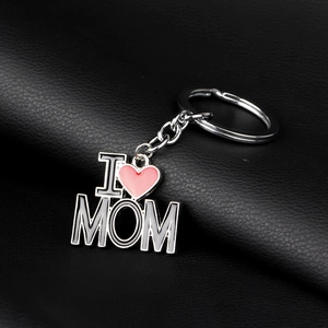 Détail du porte-clés I Love Mom avec cœur en émail rose sur fond de cuir noir texturé