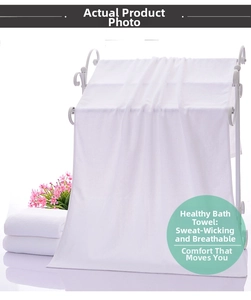 Detail showing thick white cotton hotel bath towels hanging on a rack with soft texture