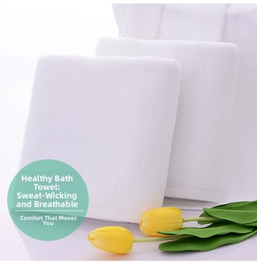 Close-up of neatly folded white hotel bath towels in soft cotton terry fabric texture