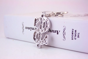 Macro view of dollar sign keychain with inlaid rhinestones on a metal ring and chain