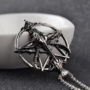 Macro shot of silver vintage Baphomet goat head pendant with inverted pentagram star