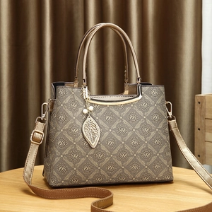 Elegante bolso jacquard oro champán con colgante floral y correa ajustable