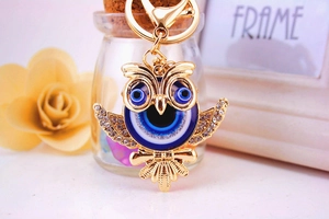 Détail du porte-clés hibou doré avec strass blancs et breloques œil de démon