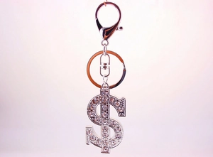 Detailed close-up of a silver dollar sign keychain with sparkling diamond accents