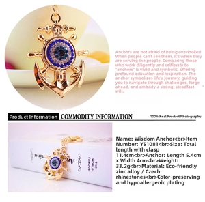 Macro detail of anchor and wheel keychain featuring blue crystals and evil eye design