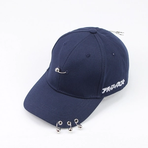 Close-up of navy canvas baseball cap with metal ring piercings and white embroidery