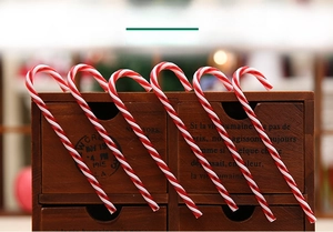 Close-up of red and white striped Christmas candy cane ornaments on a vintage wooden box