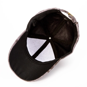 Interior detail of camouflage baseball cap showing black sweatband and metal adjuster