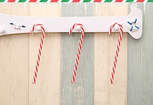 Close-up of red and white striped Christmas candy cane ornaments hanging on a rack