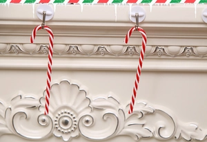 Close-up of red and white striped Christmas candy cane ornaments on a mantel