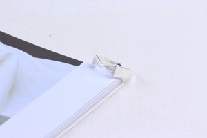Macro detail of silver ribbon bow ring showing brushed and polished finish textures