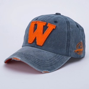Close-up of vintage washed baseball cap featuring orange letter W embroidery and frayed edges