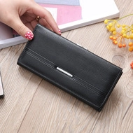 Close-up of black long wallet with lychee leather texture and silver metal buckle detail