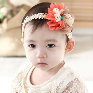 Detailed view of baby lace headband featuring a large peach and brown fabric flower