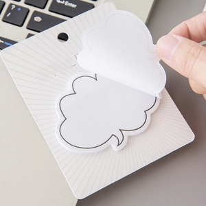 Minimalist cloud-shaped sticky notes on display card atop a laptop keyboard