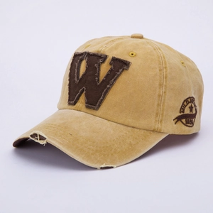 Detail of vintage washed cotton baseball cap with embroidered W patch and distressed brim