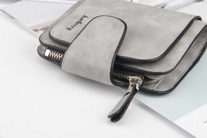 Dettaglio macro del portafoglio grigio opaco con fibbia a scatto e scomparto con zip