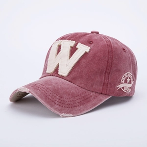 Detail of washed red baseball cap featuring vintage W patch and side embroidery textures