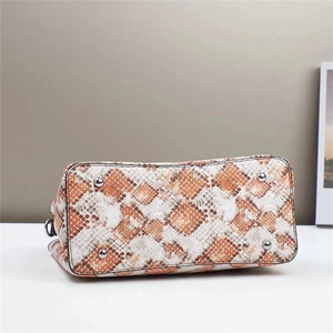Detail of snakeskin textured handbag base with four silver metal protective feet
