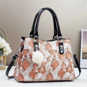 Stylish snakeskin pattern shoulder bag with quilted texture and white pompom detail