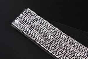 Nahaufnahme glitzernder Silber-Strasssteine auf einem schwarzen elastischen Damengürtel
