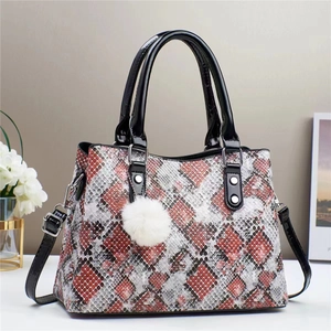 Close-up of tricolor snakeskin texture shoulder bag with stylish white fuzzy ball charm